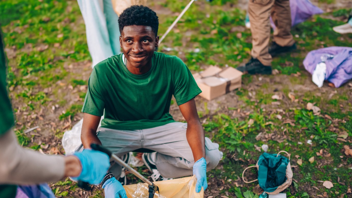 A volunteer in a green shirt smiling during a community planting event
