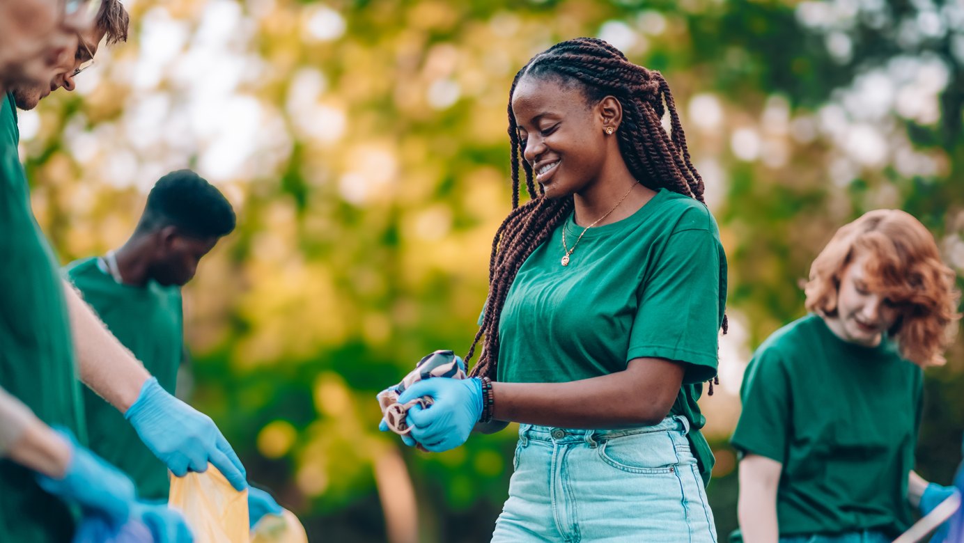 Volunteers in green shirts and gloves collecting litter together