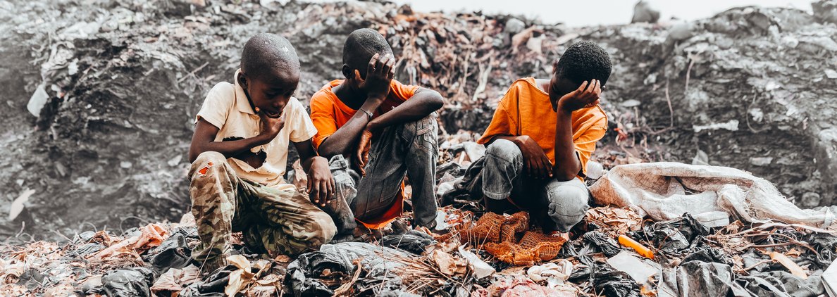 A child standing on a pile of discarded waste