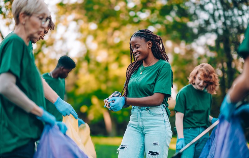 Volunteers picking up litter in a green park
